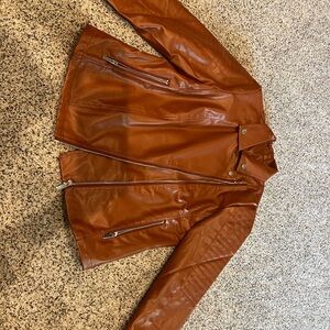 Stylish faux leather jacket with zippers .